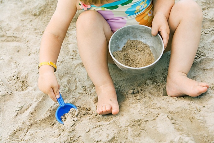 Barn som leikar i sanden.